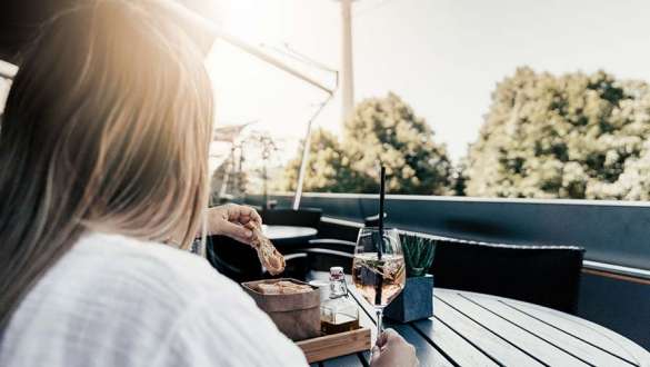 woman enjoys aperitif on panorama terrace of bmw welt 