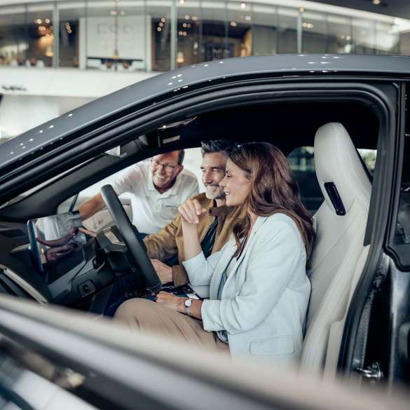 Couple receives instruction from vehicle specialists during pickup at BMW Welt