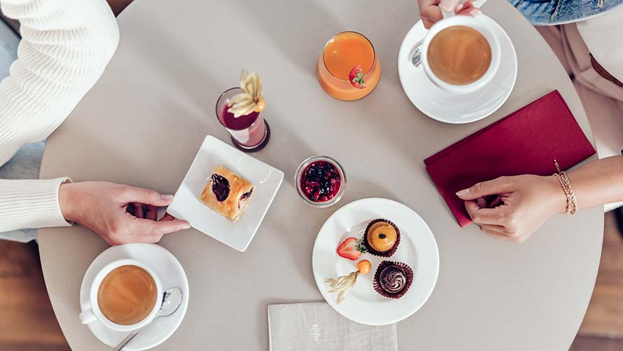 Woman and man drinking coffee and eating cake at BMW Welt