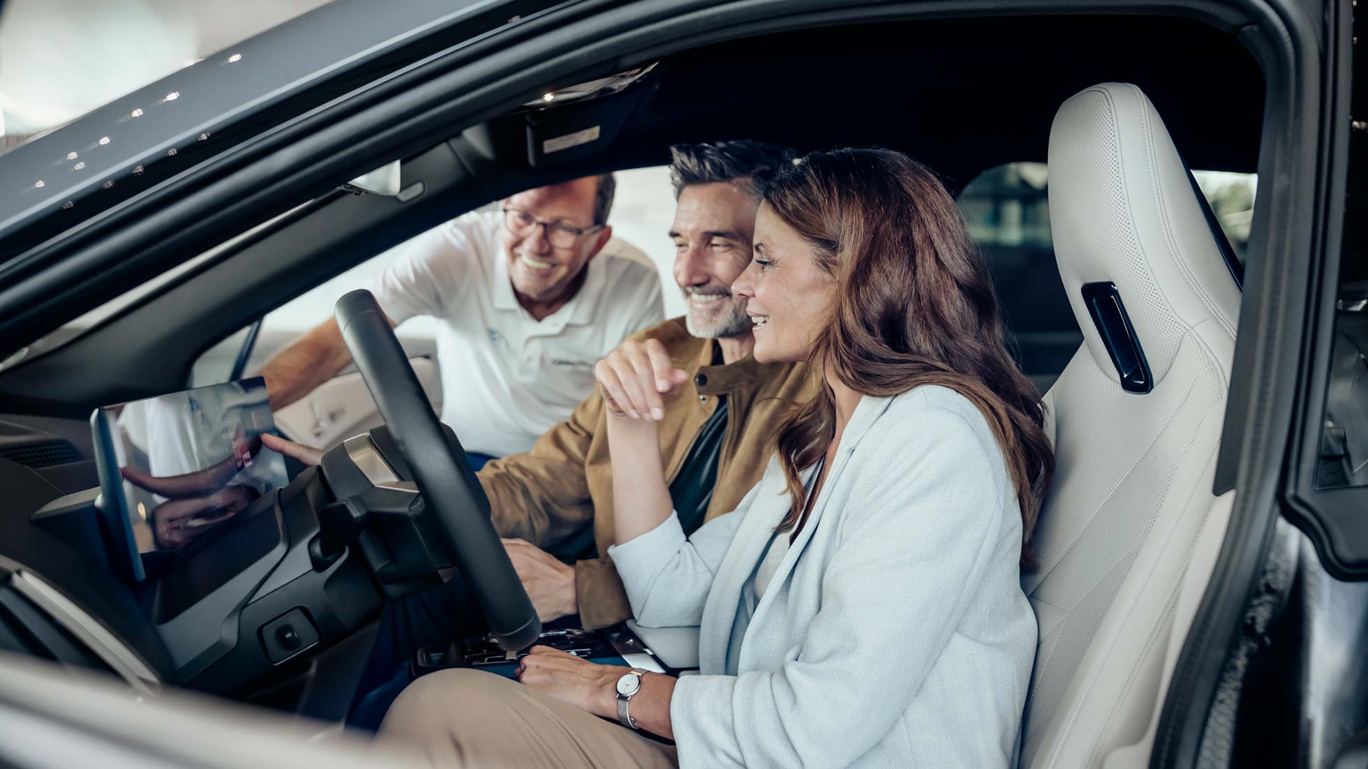 Couple receives instruction from vehicle specialists during pickup at BMW Welt