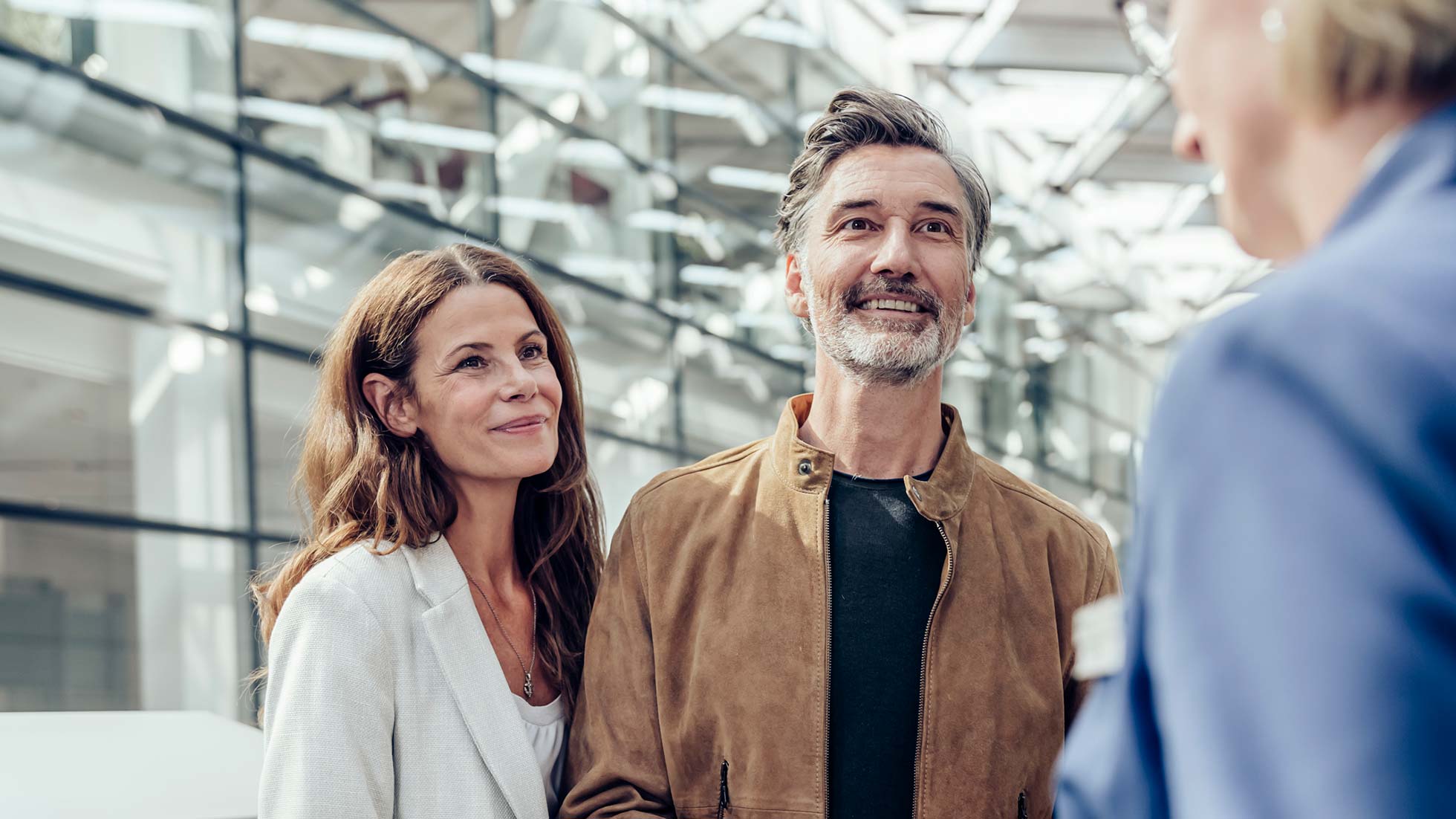 BMW Welt Tagesprogramm Glückliches Paar spricht bei einer Führung durch die BMW Welt mit ihrem Guide