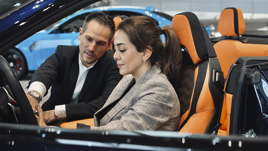 BMW Welt Consultant BMW Welt vehicle consultant explains the functions of a BMW to a customer.