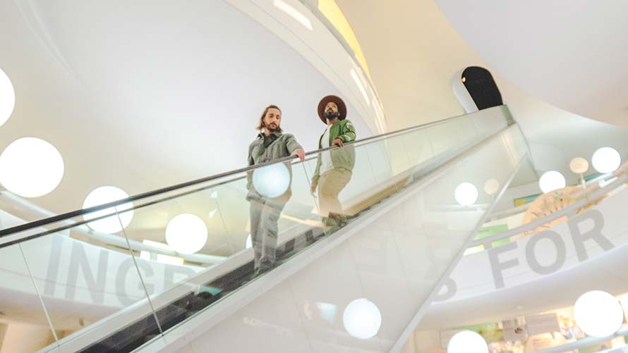 Two people ride the escalator through the BMW Museum