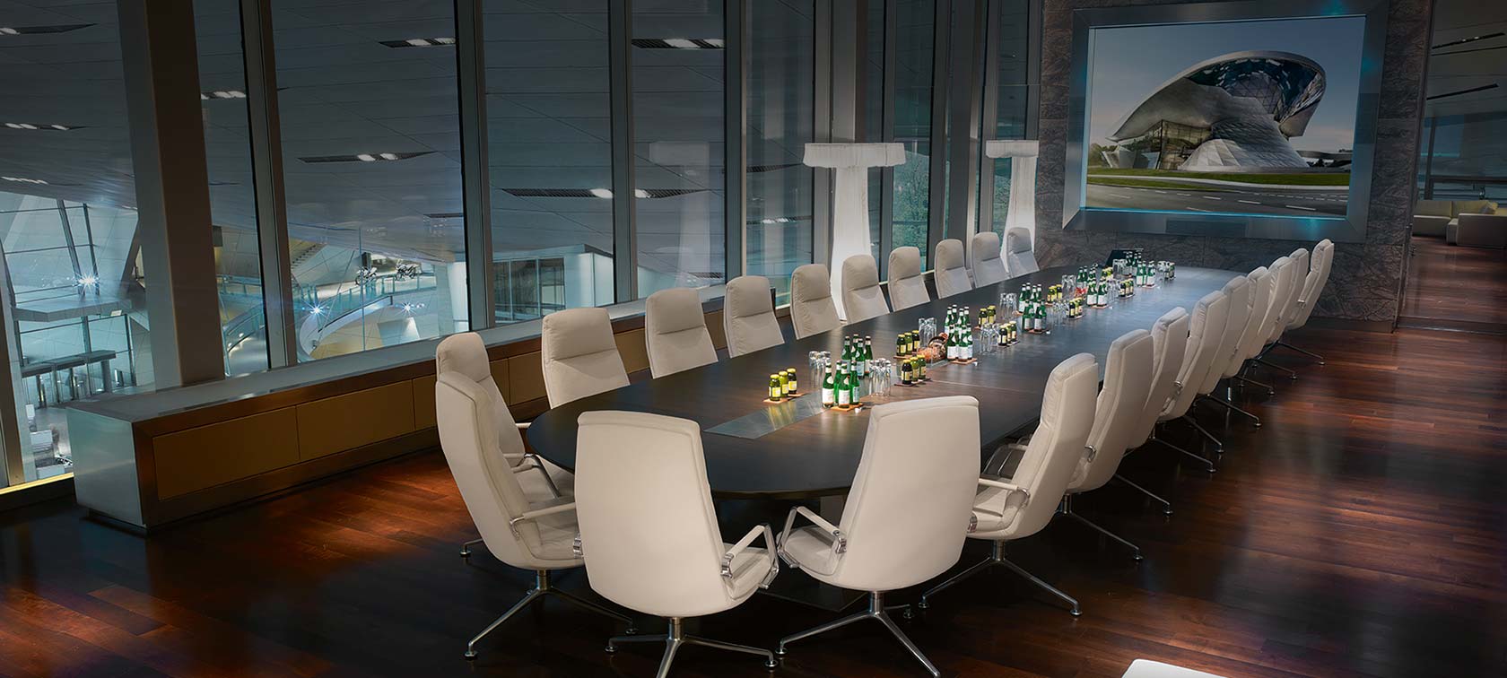 Konferenzraum mit großem Tisch und Bestuhlung im Business Club mit Ausblick über die BMW Welt