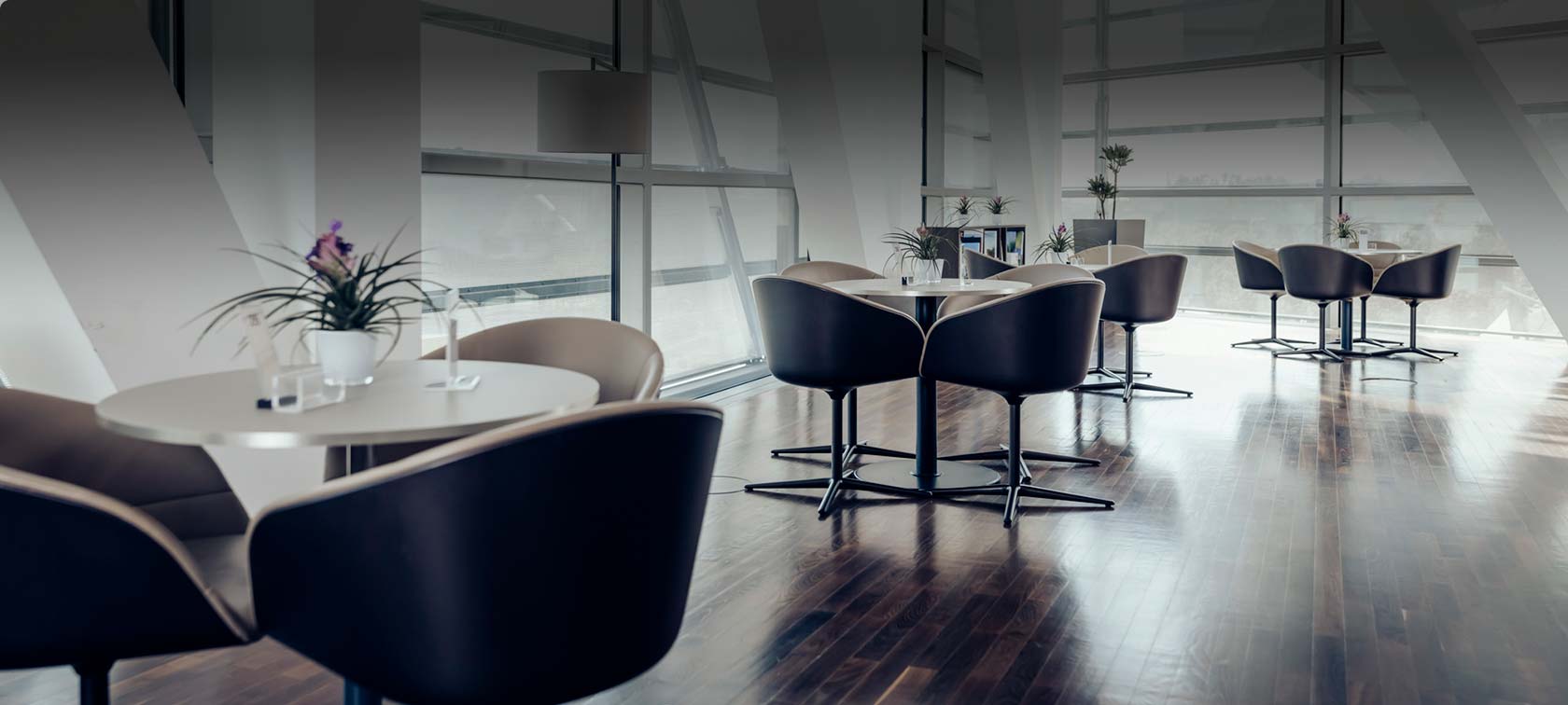 Round tables with comfortable chairs and floral decoration in the Premium Lounge of BMW Welt