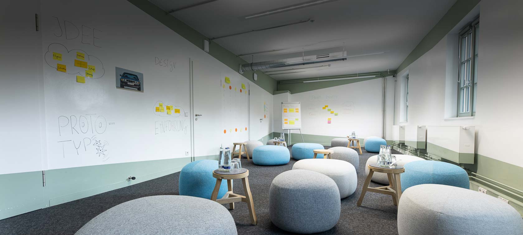 Workshopraum der BMW Group Classic mit Sitzmöbeln und Whiteboards für kreatives Arbeiten