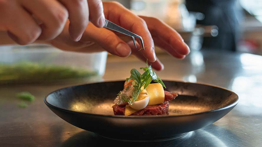 fine beef tartare is garnished with the help of tweezers in the bavarie fine beef tartare is garnished with the help of tweezers in the bavarie