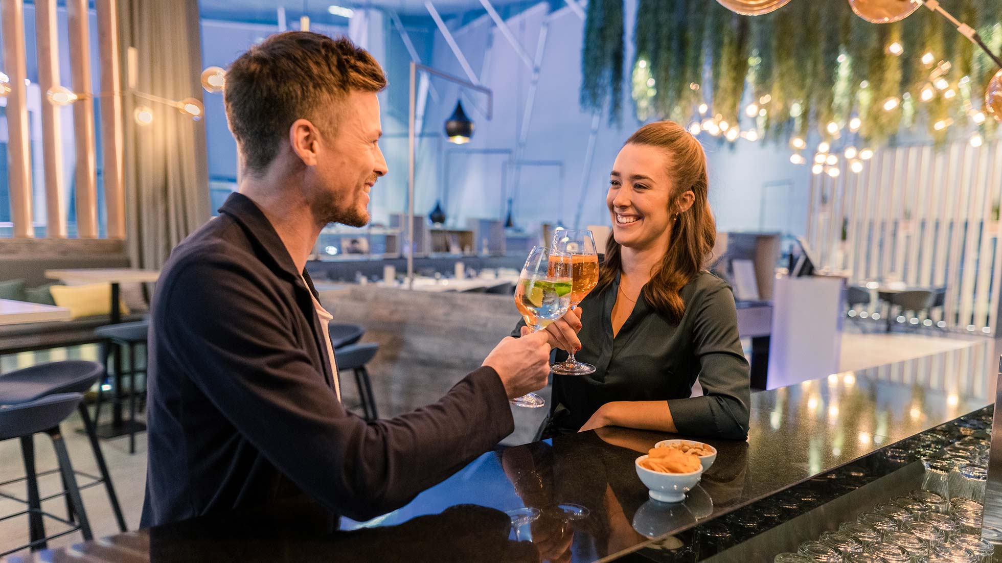 happy couple toasts with aperitif at bar in bmw welt happy couple toasts with aperitif at bar in bmw welt