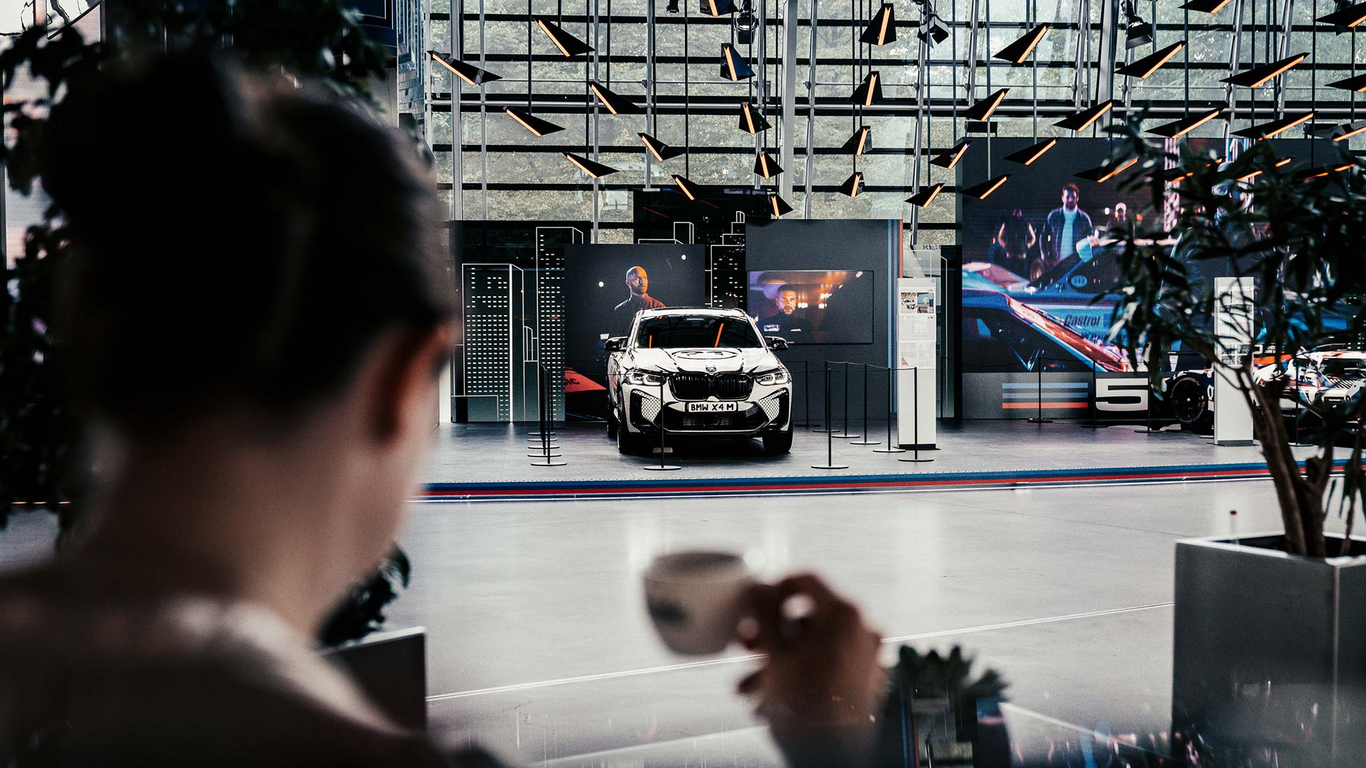 mann trinkt kaffee in coopers lounge und blickt auf die ausstellung der bmw welt mann trinkt kaffee in coopers lounge und blickt auf die ausstellung der bmw welt