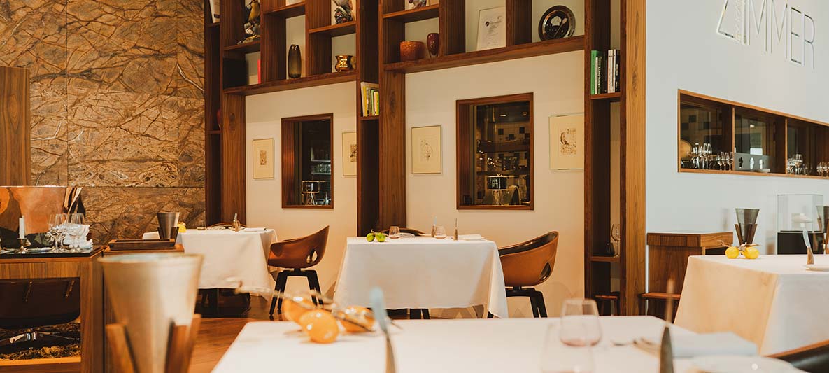 Interior with wooden elements and white covered tables