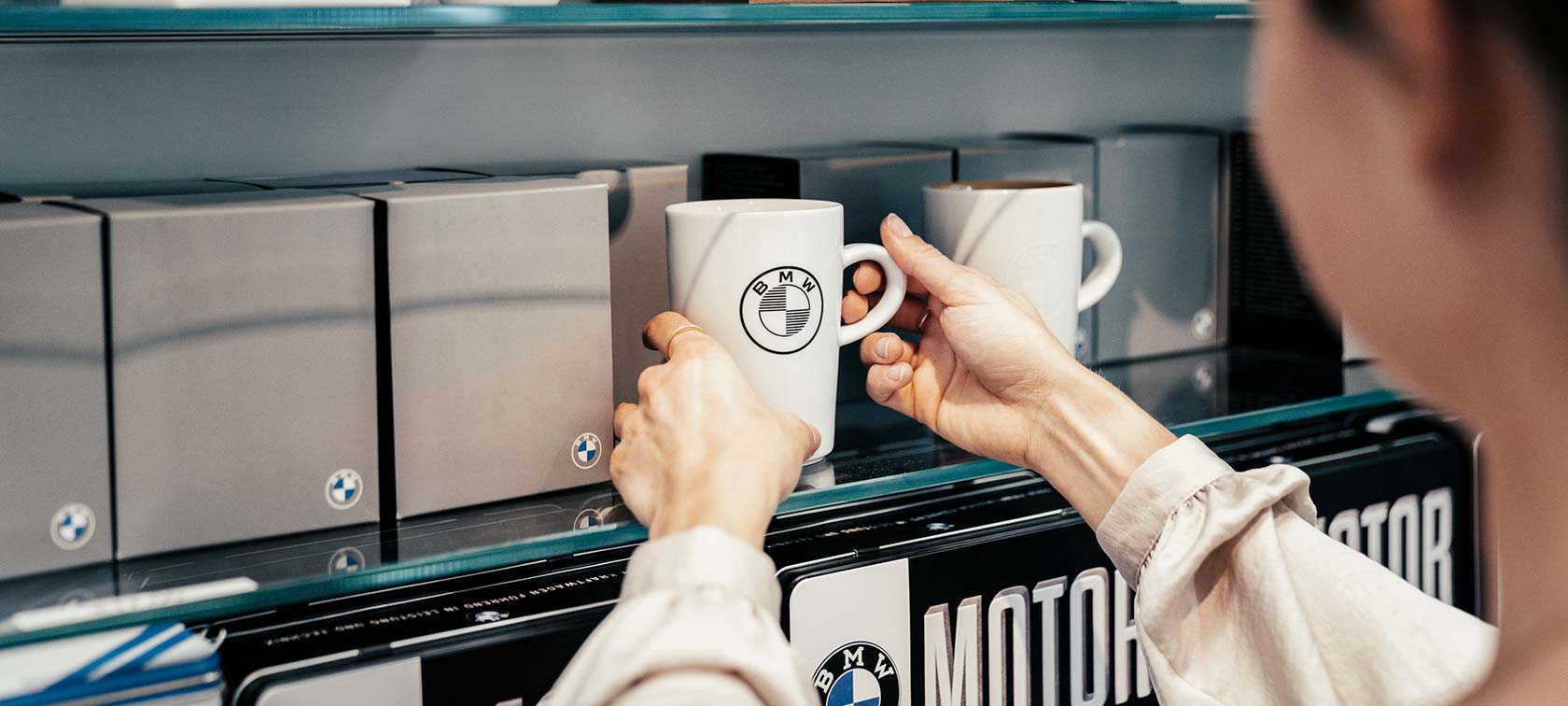 employee puts cup on shelf in bmw welt store 