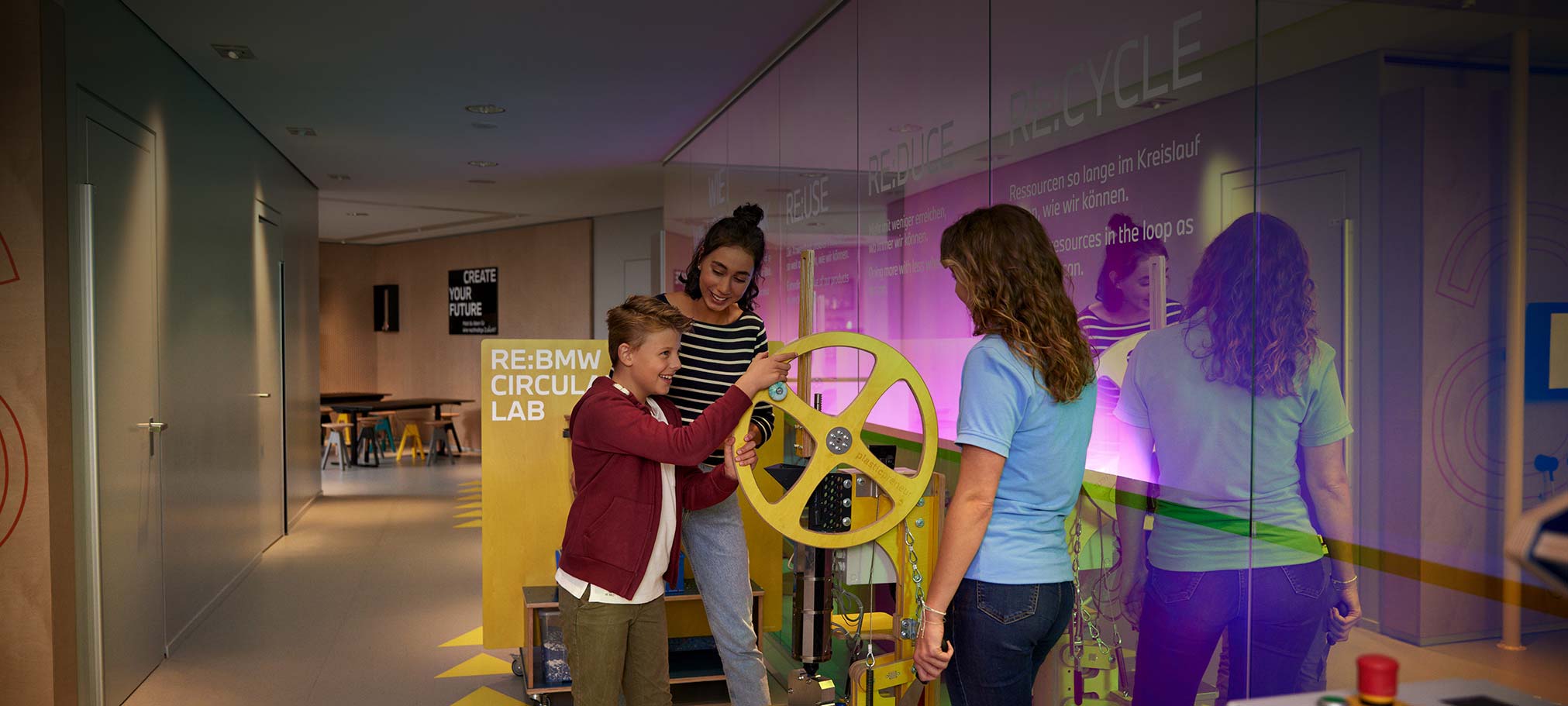 Child turns a wheel on a machine at the BMW sustainability workshop