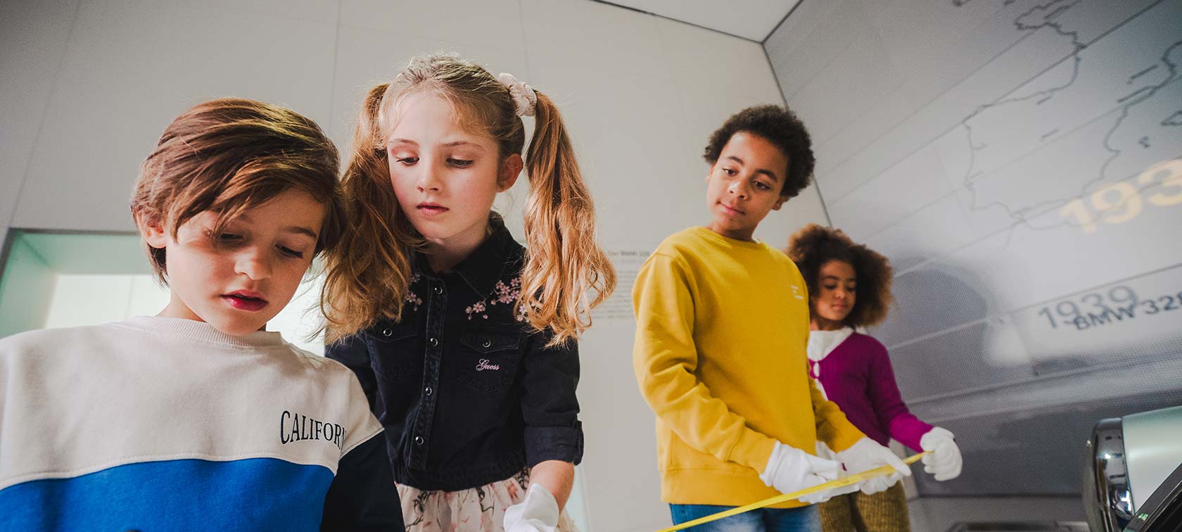 Children measure vehicles in the BMW Museum to find clues