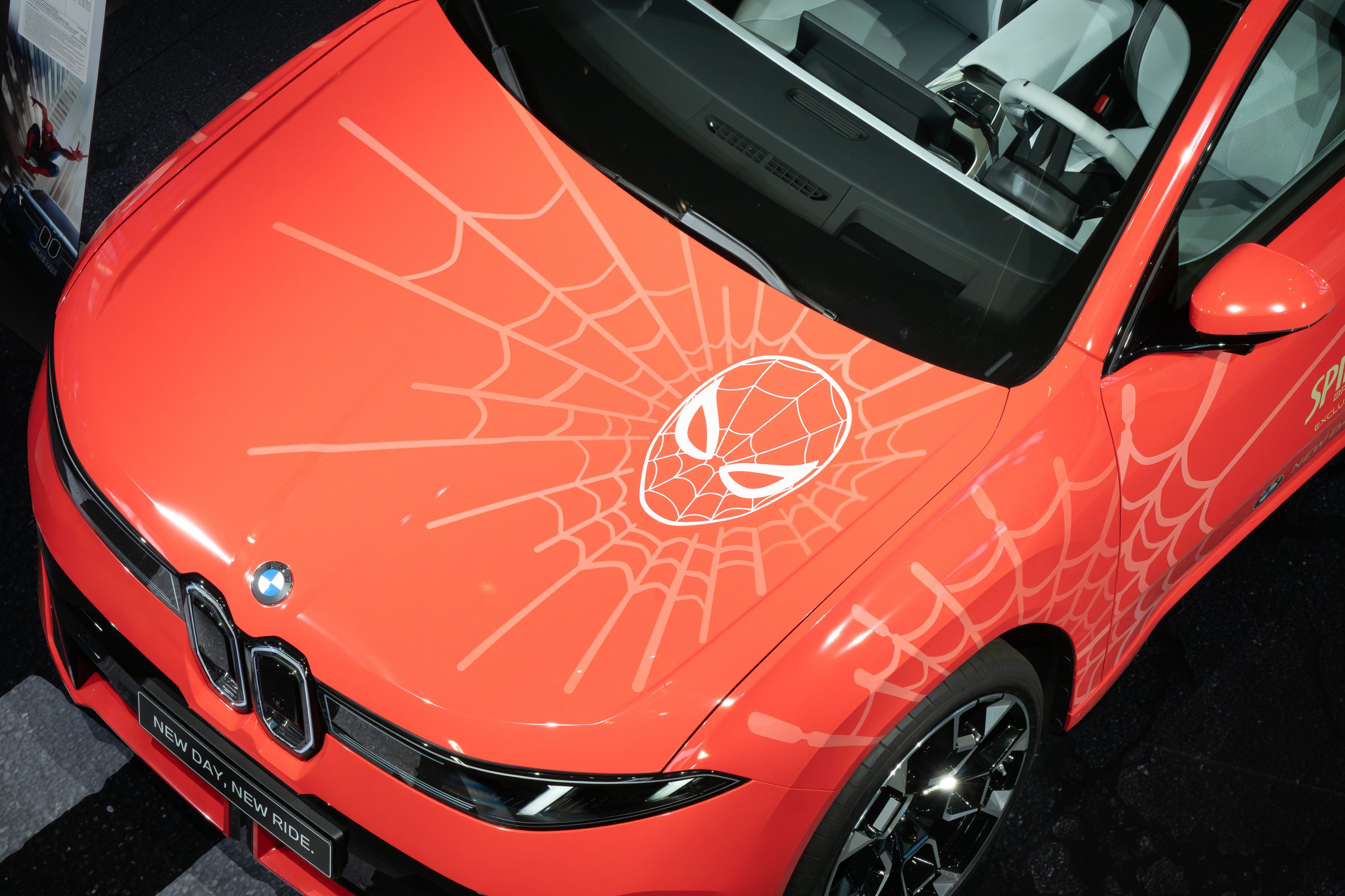 Detailansicht des BMW iX3 Flow Spider-Man™ mit Spider-Man-Motiv und Spinnennetzgrafik auf der Motorhaube.