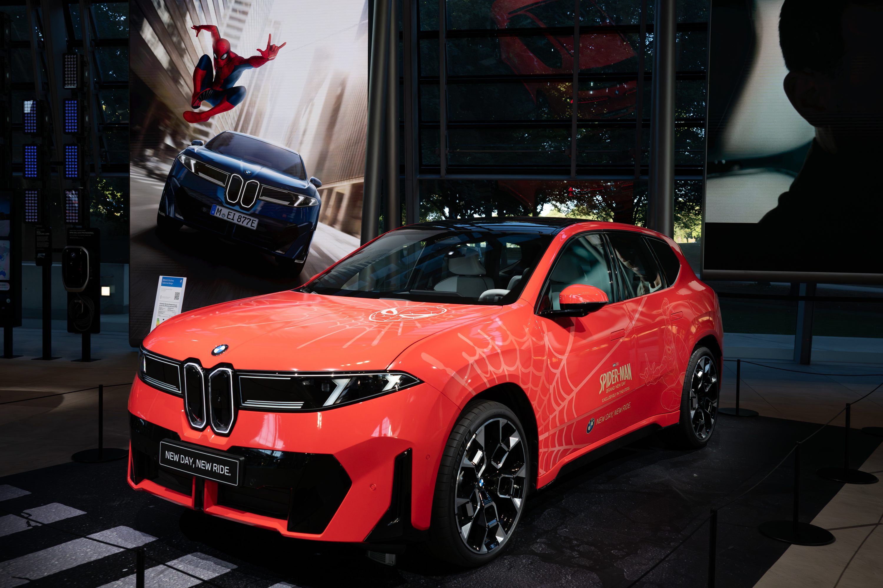 BMW iX3 Flow Spider-Man™ featuring Spider-Man-inspired graphics displayed at BMW Welt in front of a large Spider-Man visual backdrop.