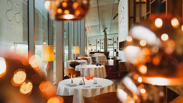 the view inside the restaurant of the BMW Welt with tables and decorations